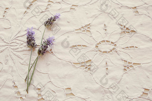 白色花卉亚麻刺绣面料背景，带薰衣草花，复古滤镜