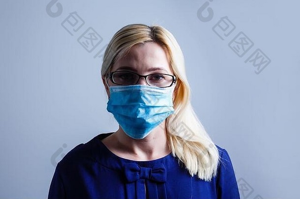 一位漂亮的年轻女子戴着纸面具以<strong>保护自己</strong>免受H1N1病毒的感染，白色隔离带上留有空间给你发短信