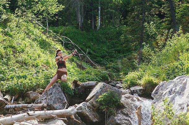 年轻漂亮的女孩亚马逊在森林里打猎时瞄准了弓，神话人物，童话故事，传说