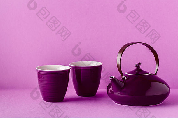 紫丁香背景上的紫色茶壶和茶杯，带有空间。