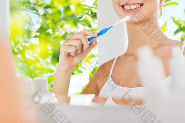 女人牙刷清洁牙齿浴室