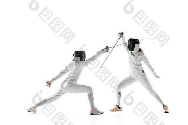 身着击剑服装的少女，手拿剑，与白色工作室背景隔离。年轻的女模特在运动、动作中练习和训练。空间。运动、年轻、健康的生活方式。