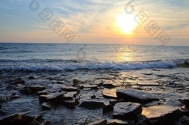 日落海岸倒影。太阳落在上半岛密歇根湖的岩石海岸上。