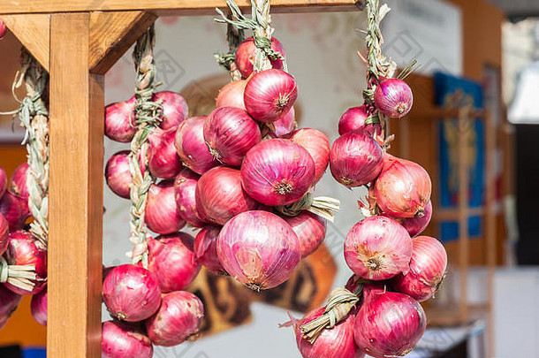 意大利农贸市场上出售的红洋葱辫子。