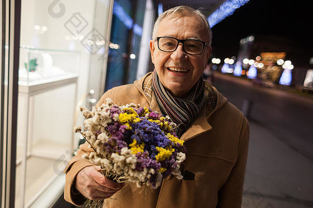 快乐的老人正在给他的妻子送花。