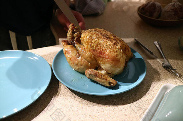 一只即将被雕刻的新鲜烤鸡的侧视图。
