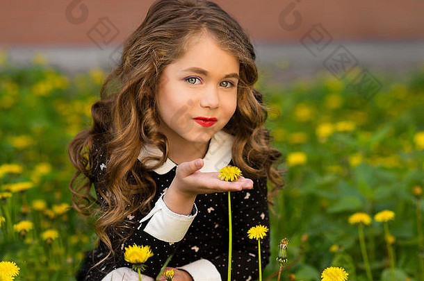 小小的令人惊异、迷人、美丽、充满幸福和喜悦的女孩，带着可爱完美的白色笑容，化妆在大绿色的田野上，布满了许多<strong>黄色</strong>的浮华
