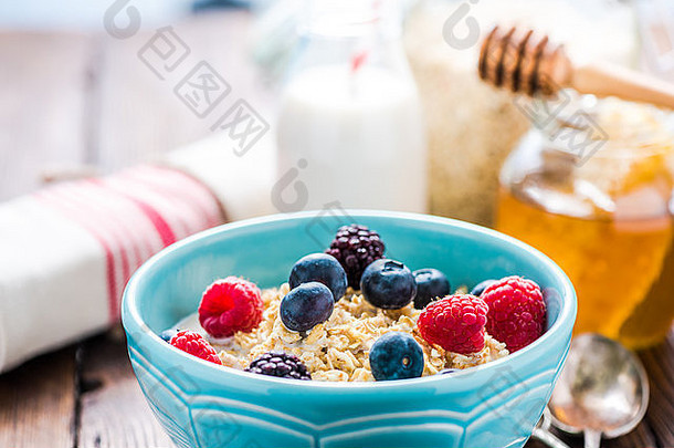 燕麦粥配夏天的浆果和蜂蜜。健康早餐的概念。