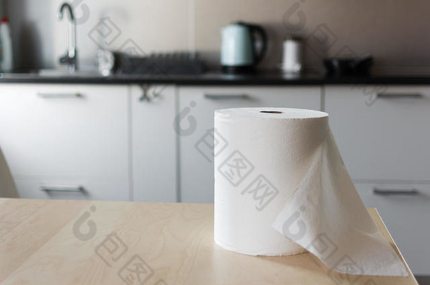 厨房桌子上放着一大卷纸巾。