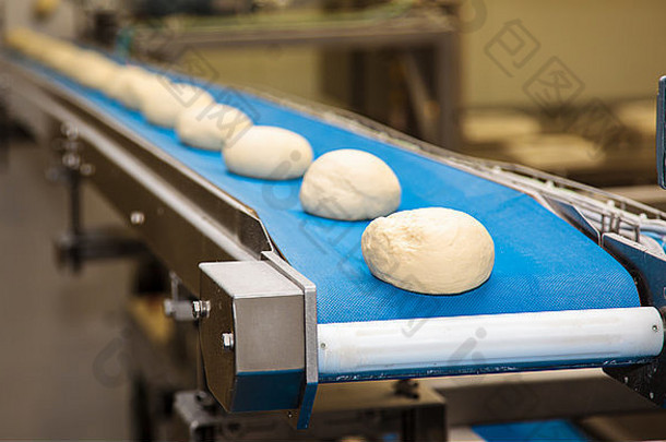 面包烘焙食品厂。生面团沿着传送带移动。