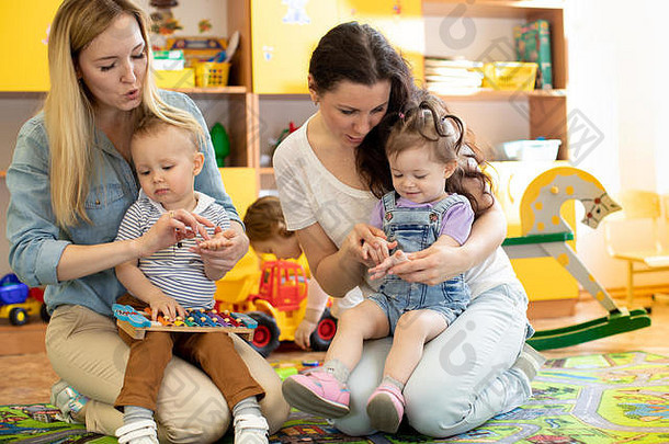 婴儿蹒跚学步的玩色彩斑斓的教育玩具母亲孩子们托儿所游戏室