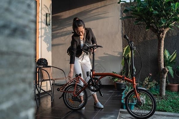 一位年轻的女企业家在家里准备一辆<strong>折叠自行车</strong>