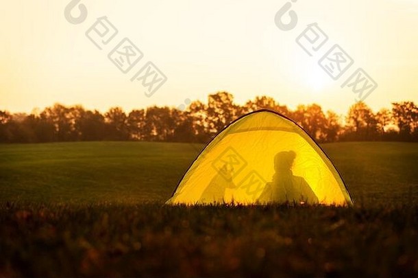 在大自然中露营和旅行，帐篷里有一个女人和她的狗的身影