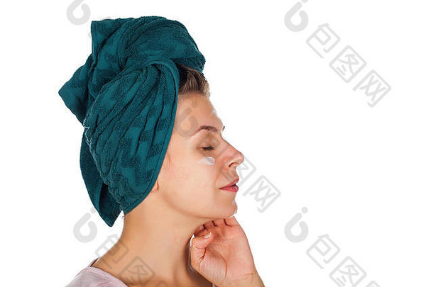 年轻的女人应用脸<strong>保湿</strong>霜淋浴穿毛巾头孤立的背景