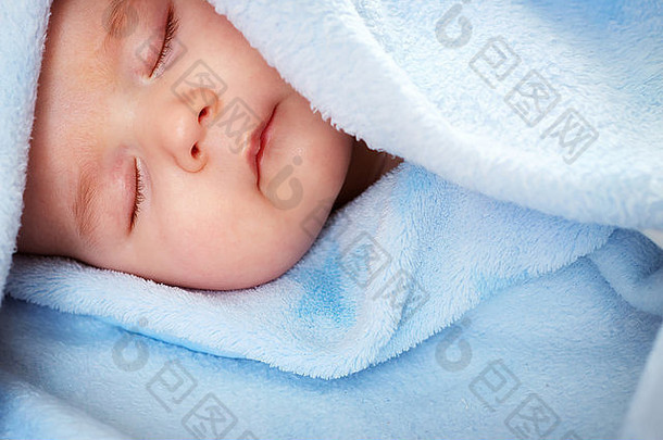 睡在蓝色毯子上的三个月大的婴儿