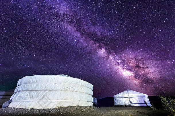 银河在蒙古戈壁沙漠的格尔营地上空。在蒙古沙漠的一个帐篷营地，数百万颗星星在夜空中闪烁。美丽的夜空，有着美丽的天空