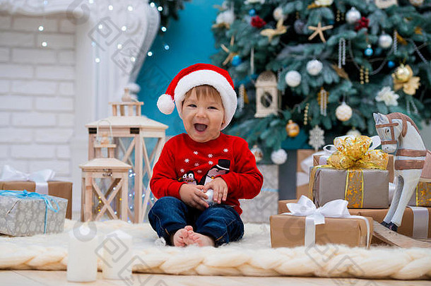 戴着圣诞帽的小圣诞老人。新年快乐，圣诞快乐。给孩子们的节日和礼物。