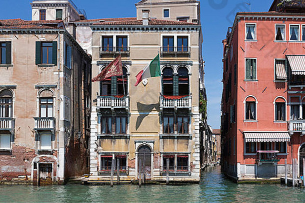 意大利威尼斯五彩缤纷的建筑沐浴在夏日的阳光和一条小运河中