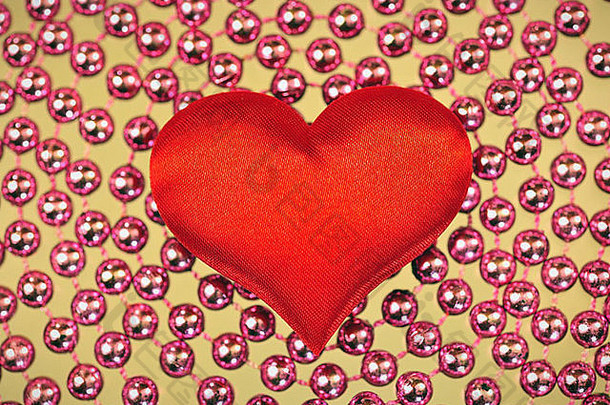 珠子背景上的丝绸红色心形图案