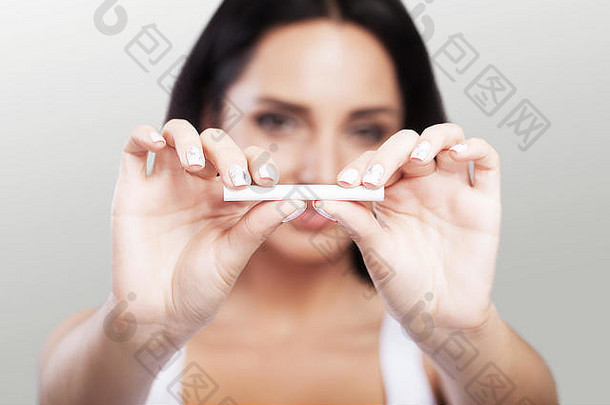 <strong>禁止吸烟</strong>。一个女人手上一支断了的香烟的特写镜头。一个女人拿着香烟的特写镜头。购买香烟的概念