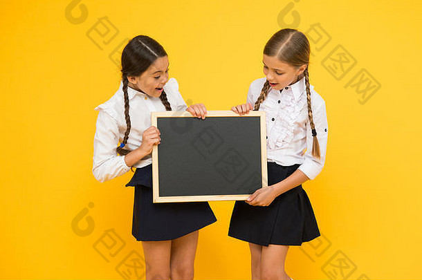 教育第一。小孩拿着黄色背景的空白黑板接受教育。小学<strong>义务教育</strong>。接受正规教育，空间。