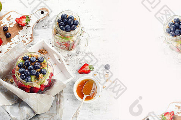 早餐用格兰诺拉麦片和玻璃罐里的浆果。健康饮食观念。俯视图