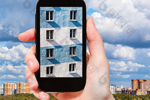 旅游概念-旅游者在智能手机上拍摄城市房屋的墙壁图片