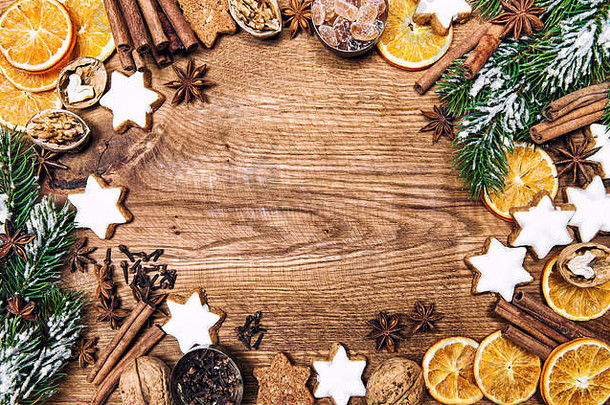圣诞装饰品、饼干和香料。乡村木质背景上的节日食品配料。复古风格色调照片