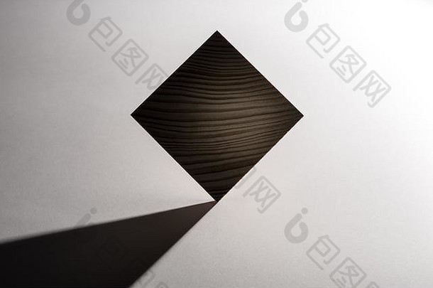 抽象几何实木立方体，在灰色背景上有真实阴影，不是3D渲染。
