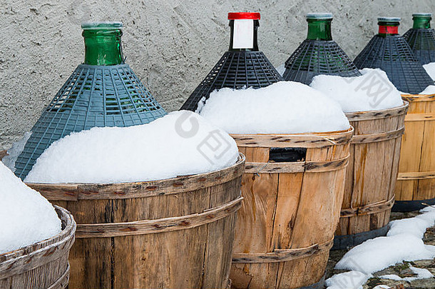 阿尔卑斯山酒馆外被雪覆盖的葡萄酒瓶