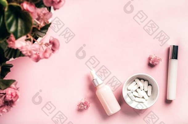化妆品瓶白色胶囊秋海棠属植物花粉红色的纸背景健康美概念