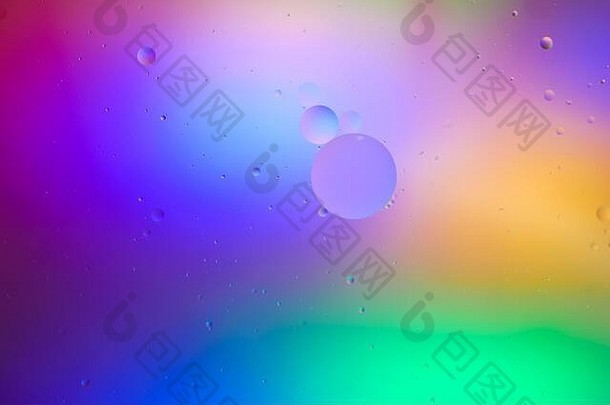 俯视图：油泡在液体中的运动。油面多色背景。奇妙的彩色泡泡结构。丰富多彩的艺术形象