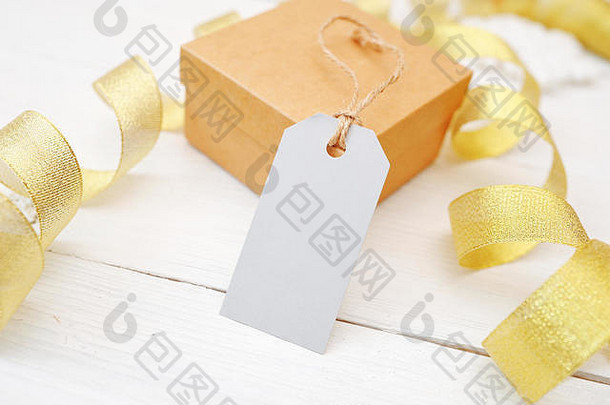 模拟圣诞礼物，白色木质背景上有空白标签，<strong>金色</strong>丝带