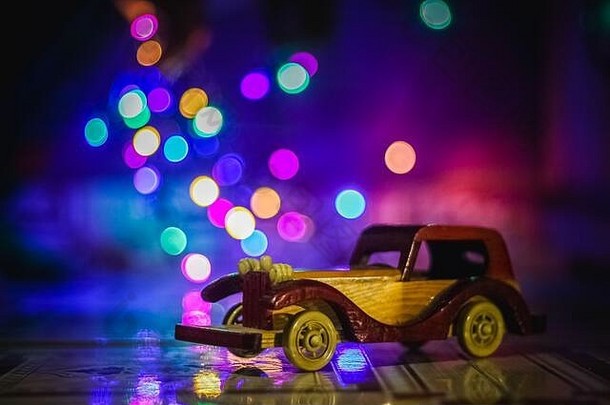圣诞灯背景上的复古玩具车。复古玩具车和bokeh库存照片。
