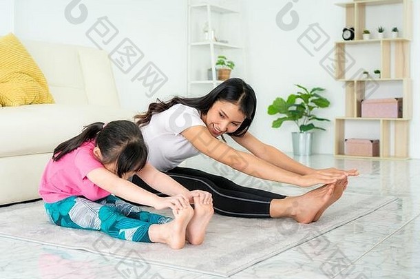 亚洲母亲和女儿在家里的起居室里做健身运动，以保持<strong>身心健康</strong>，让运动进入你的生活