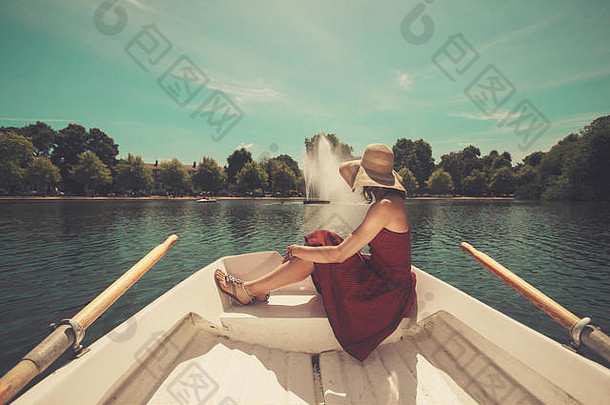 夏天，一位美丽的年轻女子在湖边的划船上放松