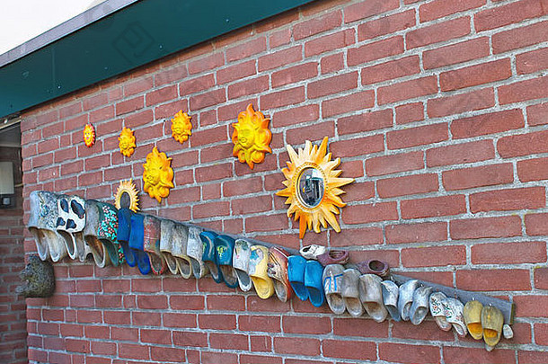 墙壁荷兰房子装饰旧鞋子和太阳。荷兰