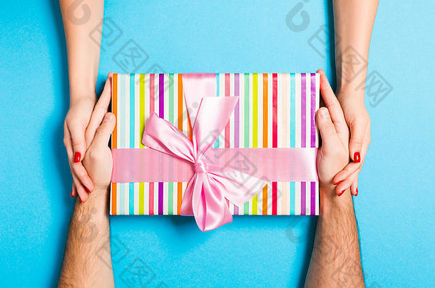 前视图男人。女人持有礼物盒子色彩斑斓的背景爱的关系概念关闭
