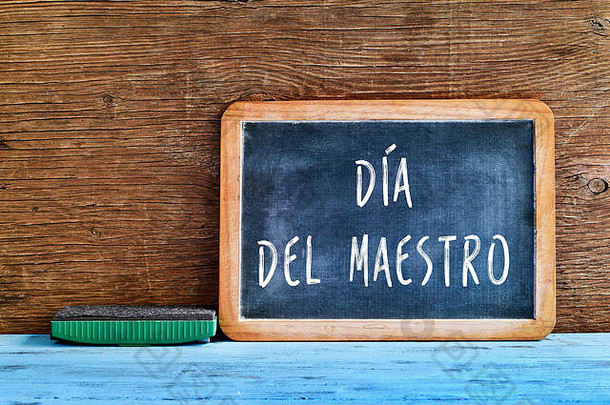 一块黑板上用西班牙语写着“<strong>教师节</strong>”，上面写着“大师迪亚”，在一张质朴的木桌上放着一块橡皮擦，带有复古的效果