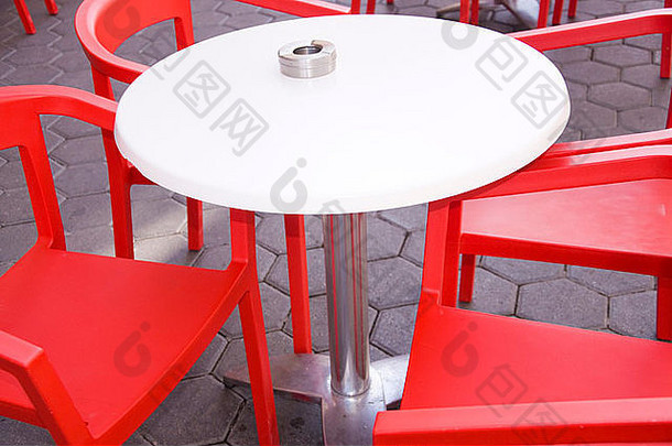 酒吧里白色桌子周围的红色椅子