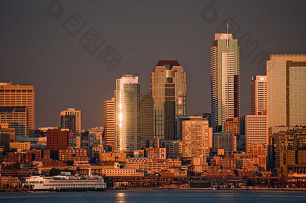 日落时拍摄的西雅图天际线。艾略特湾和渡船穿梭于市中心和班布里奇岛之间的水域。