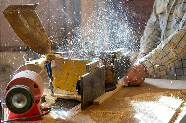 木匠用木屑将工具放在木桌上。圆锯。切割木板