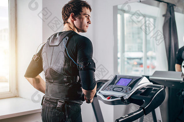 身穿黑色套装的男子在健身房跑步机上进行ems训练