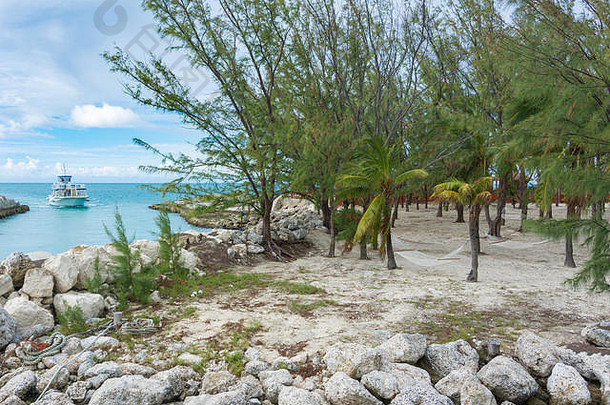 加勒比海巴哈马群岛热带天堂岛可可礁上的吊床、海滩、海洋和一艘船