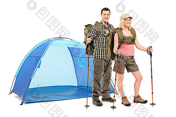 女女徒步旅行者站在蓝色帐篷旁，携带白色背景上隔离的徒步设备