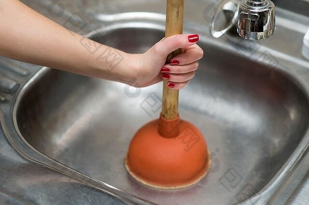 红指甲的女孩准备用柱塞<strong>清洁</strong>厨房的水槽
