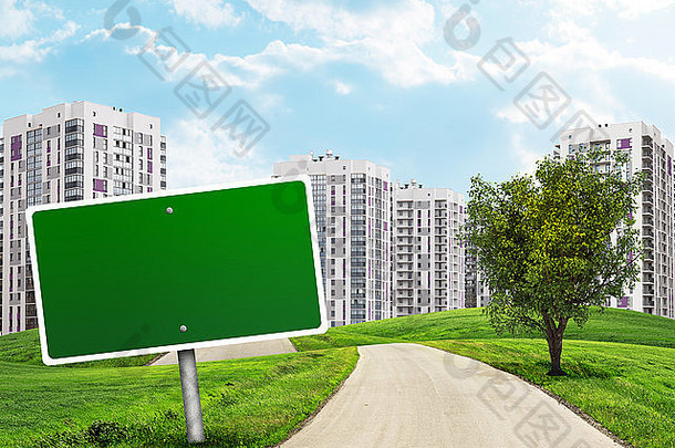 空白的绿色广告牌和路旁的树木穿过青草丛生的小山，直奔城市