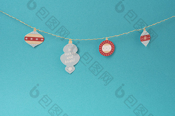 圣诞纸装饰，简单的手工圣诞标签装饰挂在空蓝色背景和空白的字符串。