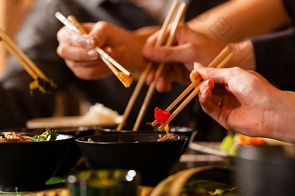 年轻的人吃泰国餐厅吃筷子特写镜头手食物