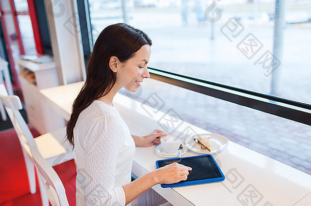 在咖啡馆，微笑着的女人拿着平板电脑和咖啡